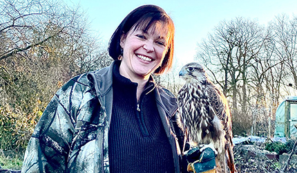 Der Falknerschein – Ausbilderin Sandra ist in der Mitte des Bildes mit einem Falken auf dem Arm